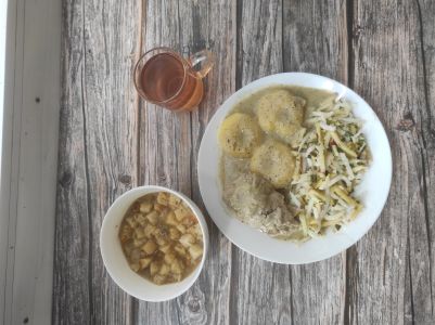 Zdjęcie przedstawia Dietę łatwostrawną: Zupa krem z białych warzyw Udziec z kurczaka wolno gotowany z ziołami Sos ziołowy Kluski śląskie Surówka z rzodkwi białej i jabłka Kompot owocowy z jabłkami Grzanki pszenne Sos ziołowy